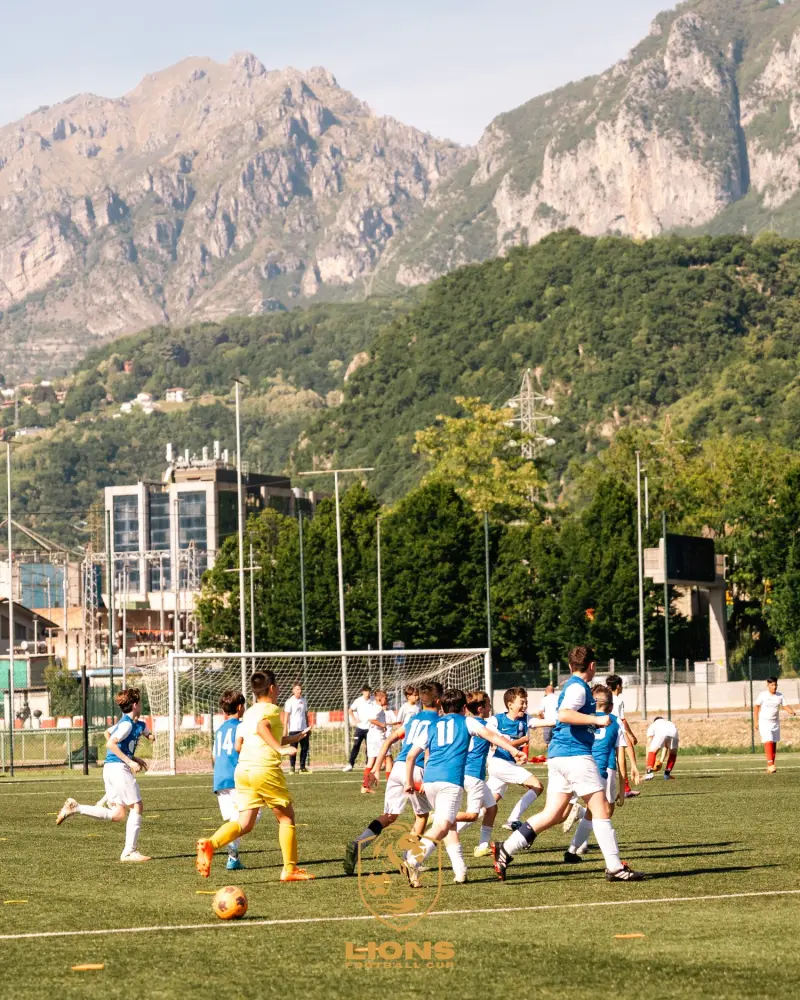 A tournament match with the Lecco mountains in the background